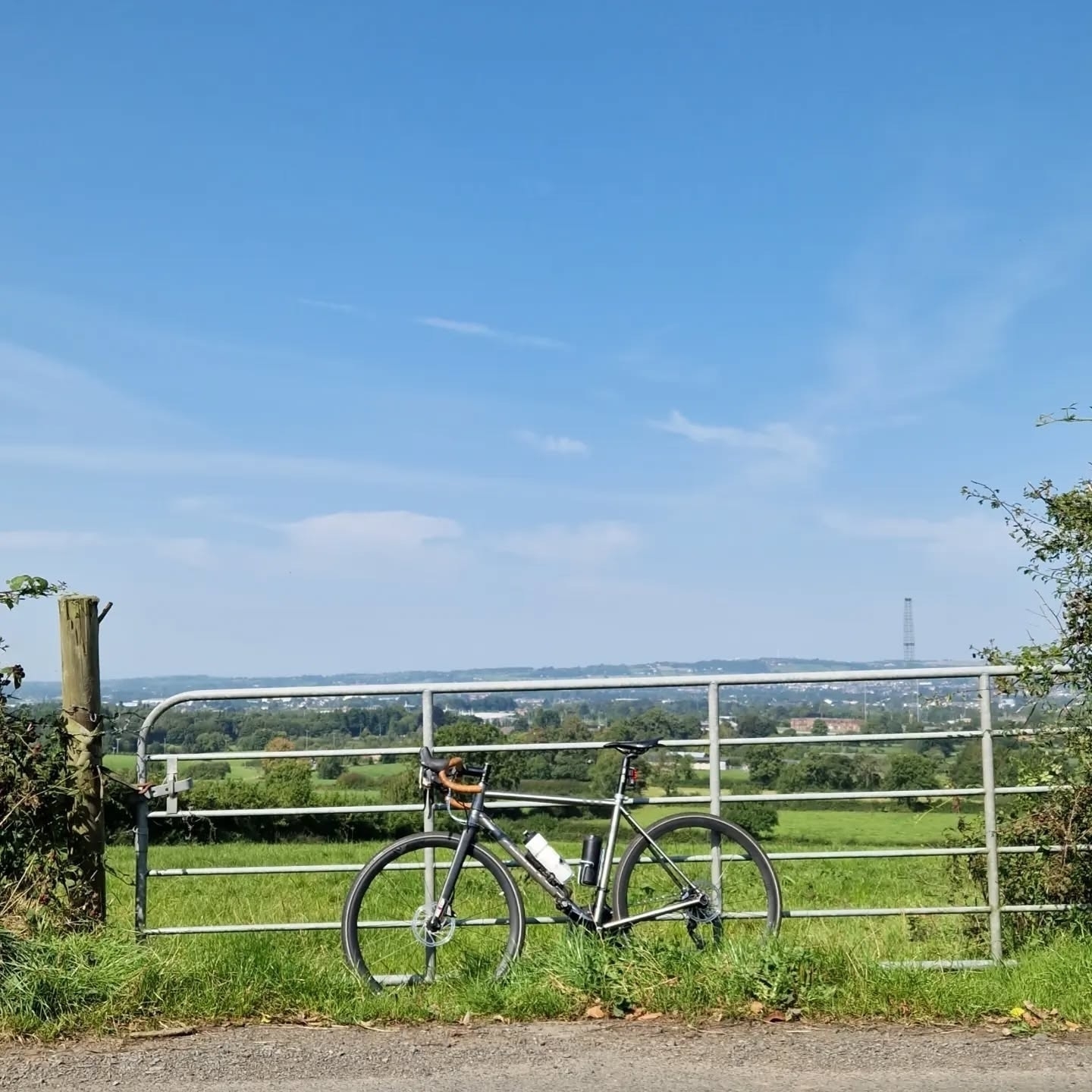 Bring me the sky: a pushbike leans against a farm gate, fields in the distance with a clear blue sky dominating